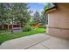 Landscaped backyard featuring a patio area, mature trees, and a relaxing hot tub at 5926 S Elkhart Ct, Centennial, CO 80016