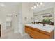Modern bathroom with double vanity sinks, wood cabinets, and natural light at 5926 S Elkhart Ct, Centennial, CO 80016