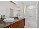 Bathroom featuring double sinks, granite countertop, and a glass enclosed shower at 5926 S Elkhart Ct, Centennial, CO 80016