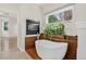 Bathroom featuring a freestanding tub, fireplace, and wood paneled accent wall at 5926 S Elkhart Ct, Centennial, CO 80016