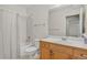 Bathroom with a shower-tub combo, white tile, and oak vanity for a clean, simple aesthetic at 5926 S Elkhart Ct, Centennial, CO 80016