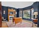 Dining room with dark blue accent wall, fireplace, and large bay windows at 5926 S Elkhart Ct, Centennial, CO 80016