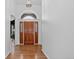 Elegant foyer with hardwood floors, an arched doorway, a wooden door, and white walls, creating a grand entrance at 5926 S Elkhart Ct, Centennial, CO 80016