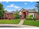 Charming red brick home features a manicured lawn, mature trees, and an inviting arched entryway, creating a welcoming curb appeal at 5926 S Elkhart Ct, Centennial, CO 80016