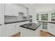 Modern kitchen featuring white cabinets, black countertops, and a center island at 5926 S Elkhart Ct, Centennial, CO 80016