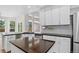 Modern kitchen with white cabinets, large windows and island at 5926 S Elkhart Ct, Centennial, CO 80016