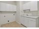Well-lit laundry room offers tile flooring and ample cabinet space for storage at 5926 S Elkhart Ct, Centennial, CO 80016