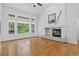Bright living room with hardwood floors, large windows, a fireplace, and high ceilings, creating a comfortable atmosphere at 5926 S Elkhart Ct, Centennial, CO 80016