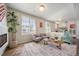 Bright living room featuring large windows, a cozy seating area, fireplace, and stylish decor at 22072 E 38Th Pl, Aurora, CO 80019