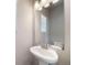 Stylish powder room with a pedestal sink, decorative mirror, and modern fixtures at 22072 E 38Th Pl, Aurora, CO 80019