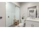 Modern bathroom featuring a tiled shower with glass door, single vanity, and white fixtures at 5735 Boston St, Denver, CO 80238