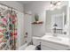 Stylish bathroom with colorful shower curtain, white vanity, and ample natural light for a fresh feel at 5735 Boston St, Denver, CO 80238