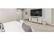 Bright bedroom with a large television, sliding closet doors, and a neutral color scheme at 5735 Boston St, Denver, CO 80238