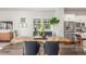 Dining area with unique wood table, modern chairs, and stainless steel appliances at 5735 Boston St, Denver, CO 80238