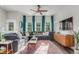 Sunlit living room with a large sectional sofa, colorful rug, and modern decor at 5735 Boston St, Denver, CO 80238