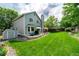 Expansive backyard with lush green lawn, mature trees, patio and a tool shed at 1387 Mcintosh Ave, Broomfield, CO 80020