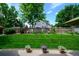 Spacious backyard with lush green lawn, mature trees, and a charming flower bed at 1387 Mcintosh Ave, Broomfield, CO 80020