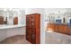 Bathroom featuring brown cabinets, mirrors, and neutral color palette at 1387 Mcintosh Ave, Broomfield, CO 80020