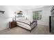 Cozy bedroom with an iron bed frame, window view, and warm lighting on a bedside table at 1387 Mcintosh Ave, Broomfield, CO 80020
