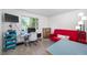 Bedroom featuring desk, TV, and red futon, perfect for creative endeavors or relaxation at 1387 Mcintosh Ave, Broomfield, CO 80020