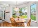 Sun-filled breakfast nook featuring a round table, wooden chairs, and views of the landscaped backyard at 1387 Mcintosh Ave, Broomfield, CO 80020