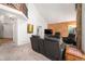 Bright living room with high ceilings and a decorative brick fireplace, a staircase and wood paneling at 1387 Mcintosh Ave, Broomfield, CO 80020