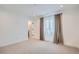 Bright bedroom featuring neutral carpet, a window with curtains, and crisp white trim at 2599 S Cherokee St, Denver, CO 80223