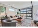 Bright living room with a unique garage-style window door, modern furniture, and stylish decor at 2599 S Cherokee St, Denver, CO 80223