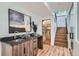 Wet bar with stone countertop, adjacent to stairs and a glass-enclosed wine cellar at 2599 S Cherokee St, Denver, CO 80223