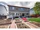 Spacious backyard with garden beds, a brick patio, a lush lawn, and ample space for outdoor entertaining at 4907 Fenwood Dr, Highlands Ranch, CO 80130