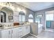 Modern bathroom with double sinks, updated fixtures and large mirrors at 4907 Fenwood Dr, Highlands Ranch, CO 80130