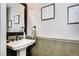 Elegant half bathroom featuring a pedestal sink and decorative wall art at 4907 Fenwood Dr, Highlands Ranch, CO 80130