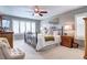 Cozy bedroom with a queen-size bed, ceiling fan, and large window with blinds at 4907 Fenwood Dr, Highlands Ranch, CO 80130