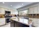 Well-appointed kitchen with granite countertops, stainless steel appliances, and a center island at 4907 Fenwood Dr, Highlands Ranch, CO 80130