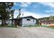 Exterior shot of the house showcasing its gravel driveway, trees, and partial siding details at 32 Magnum Bonum Dr, Breckenridge, CO 80424