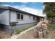 Exterior view of home with a pile of firewood and well-maintained landscaping at 32 Magnum Bonum Dr, Breckenridge, CO 80424