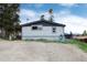 Home exterior with a gravel driveway, gray siding, well-kept lawn, and mountain views at 32 Magnum Bonum Dr, Breckenridge, CO 80424