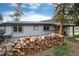 Exterior view of the property with a large stack of firewood and a well-maintained lawn at 32 Magnum Bonum Dr, Breckenridge, CO 80424