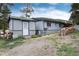 Quaint home featuring neutral horizontal siding, a white door, and a simple gravel yard at 32 Magnum Bonum Dr, Breckenridge, CO 80424