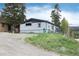 Exterior of home with gray siding, trimmed yard, and a gravel driveway at 32 Magnum Bonum Dr, Breckenridge, CO 80424