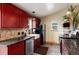 Stylish kitchen with red cabinetry, stone countertops, stainless steel appliances, and farmhouse sink at 32 Magnum Bonum Dr, Breckenridge, CO 80424
