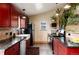 Kitchen with red cabinetry, granite counters, stainless appliances, eat-in dining, and plants at 32 Magnum Bonum Dr, Breckenridge, CO 80424