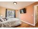 Bedroom featuring hardwood floors, neutral walls, a large window, and an attached TV at 10661 W 104Th Ave, Broomfield, CO 80021