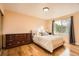 Bright bedroom with hardwood floors, a large window, and a queen bed at 10661 W 104Th Ave, Broomfield, CO 80021