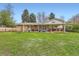 Expansive backyard with lush lawn, brick accents, covered patios, and mature trees for privacy at 6238 S Cherry Cir, Centennial, CO 80121