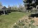 Expansive backyard featuring lush green grass, mature trees, and a black metal fence at 6238 S Cherry Cir, Centennial, CO 80121