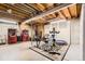 View of the basement featuring laundry machines, fitness equipment and exposed rafters at 6238 S Cherry Cir, Centennial, CO 80121