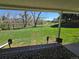Relaxing view from a covered patio overlooking a spacious backyard with a metal fence and green trees at 6238 S Cherry Cir, Centennial, CO 80121
