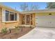 Charming front entrance of brick home, featuring a decorative front door, manicured landscaping, and attached two car garage at 6238 S Cherry Cir, Centennial, CO 80121