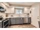 Updated kitchen features sleek gray cabinets, stainless steel dishwasher and a sunlit window over a stainless steel sink at 6238 S Cherry Cir, Centennial, CO 80121